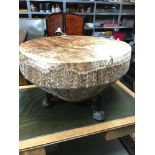 A Large African cow skin floor drum/ coffee table, on three hoof feet.