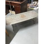 A Retro coffee table designed with a metal base, spar like shelf with white finials and hard plastic