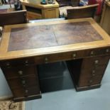 A Victorian brown leather top knee hole desk fitted with original gilt brass lion head and hoop