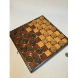 A Vintage/ Antique travel chess board together with a set of Checkers.