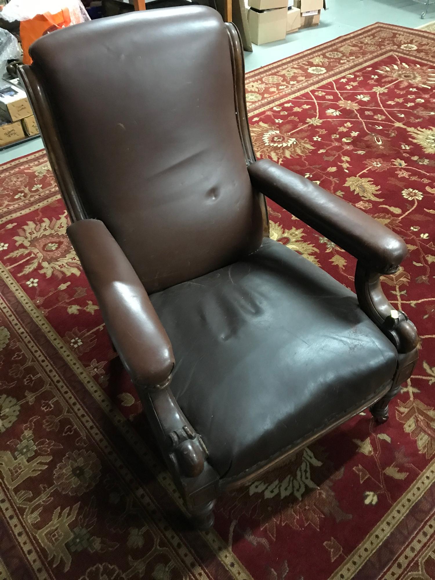 A stylish and rustic Victorian library arm chair, upholstered with brown leather and stud finish