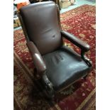 A stylish and rustic Victorian library arm chair, upholstered with brown leather and stud finish