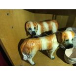 A Pair of Staffordshire St Bernard left and right facing dog figures. Both have glass eyes.