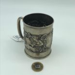 A Birmingham silver highly detailed mug depicting raised Greek style lady figures to the centre