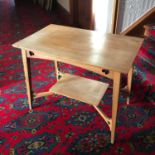 An Arts and crafts light oak two tier window table.
