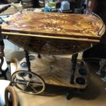 A Vintage ornate inlaid drinks trolley.