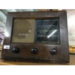 A Vintage Bush radio fitted with a bluetooth receiver. In a working condition and lights up.