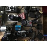 A Collection of vintage cameras and lenses to include praktica electronic BMS, Olympus OM10, Zenit