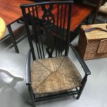 An arts & crafts fireside arm chair with high spindle back & weaved wicker base