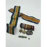 A Miniature set of WW2 Medals with two large additional ribbons and a gold coloured brooch set