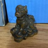 A Japanese hand carved netsuke of a foo dog signed by the artist. Measures 5cm in height