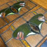 A Pair of antique stain glass window panels. Showing a butterfly shape to the centre. Measures 40.