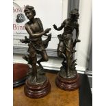 A Pair of antique bronze spelter figurines after CH. LEVY. Signed to the backs. Sat upon hardwood