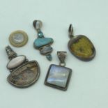A Lot of four unusual large silver pendants with precious and hard stone inserts.