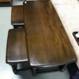 A Vintage Ercol elm wood side table with two pull out smaller tables. Large table measures