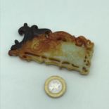 A Finely carved Chinese jade token/ pendant showing dark brown tinges.