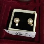 A Pair of 18ct gold ladies earrings set with single pearls and Clear Stones