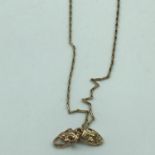 A 9ct gold unusual necklace with two 9ct gold mask pendants. Weighs 2.96grams