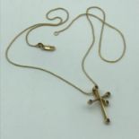 An 18ct gold necklace with an 18ct gold cross like pendant with clear stones. Weighs 5.45grams