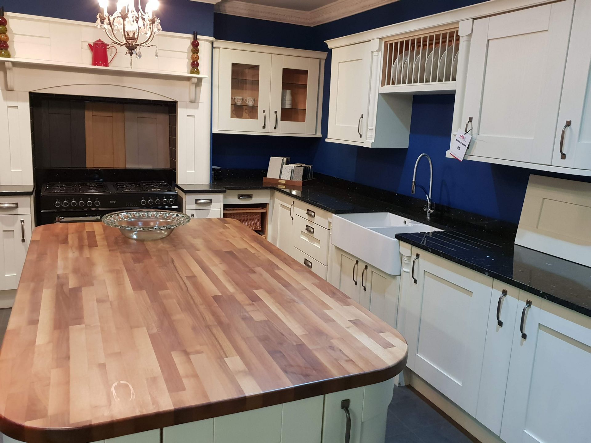 Cream fitted display kitchen with black granite work surface