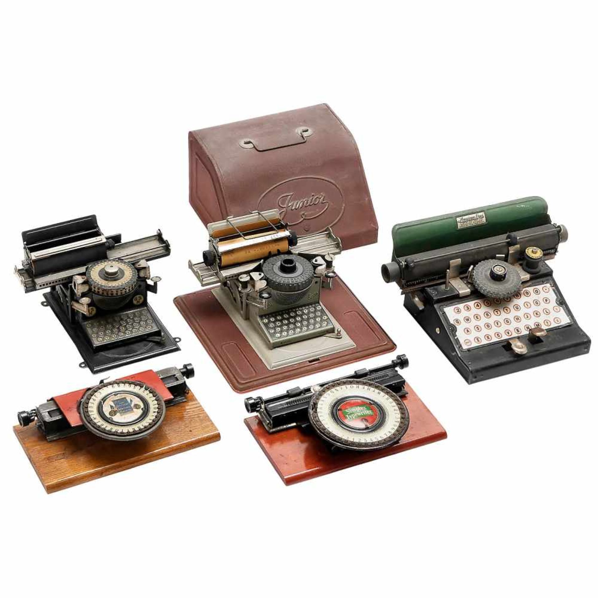 5 Toy Typewriters1) Simplex Souvenir Typewriter, 1903, dial, lithographed tin, on wood base,