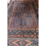 A Baluchi carpet, the ground field of comparted design, holed, 184 x 314cm