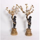 A pair of bronze and gilt bronze 7-branch candelabra, in the form of putto holding cornucopia with