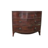 A George IV mahogany bowfront chest with a brushing slide above three graduated drawers, on swept