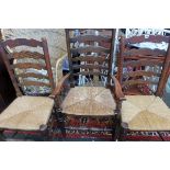 A set of five oak ladderback chairs with rush seats to include one armchair