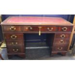 A George III style mahogany kneehole desk with inset writing surface, with drawers and a cupboard to