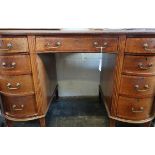 An Edwardian mahogany and cross banded kidney shape desk with nine short drawers, on square tapering