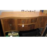 A George III style serpentine fronted mahogany sideboard with cupboards and drawers on square