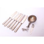 A set of six silver handled butter knives, an electroplated tea strainer, a bookmark and a white