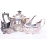 A three piece sterling silver tea set, with half reeded decoration and ebony handle, tea pot by