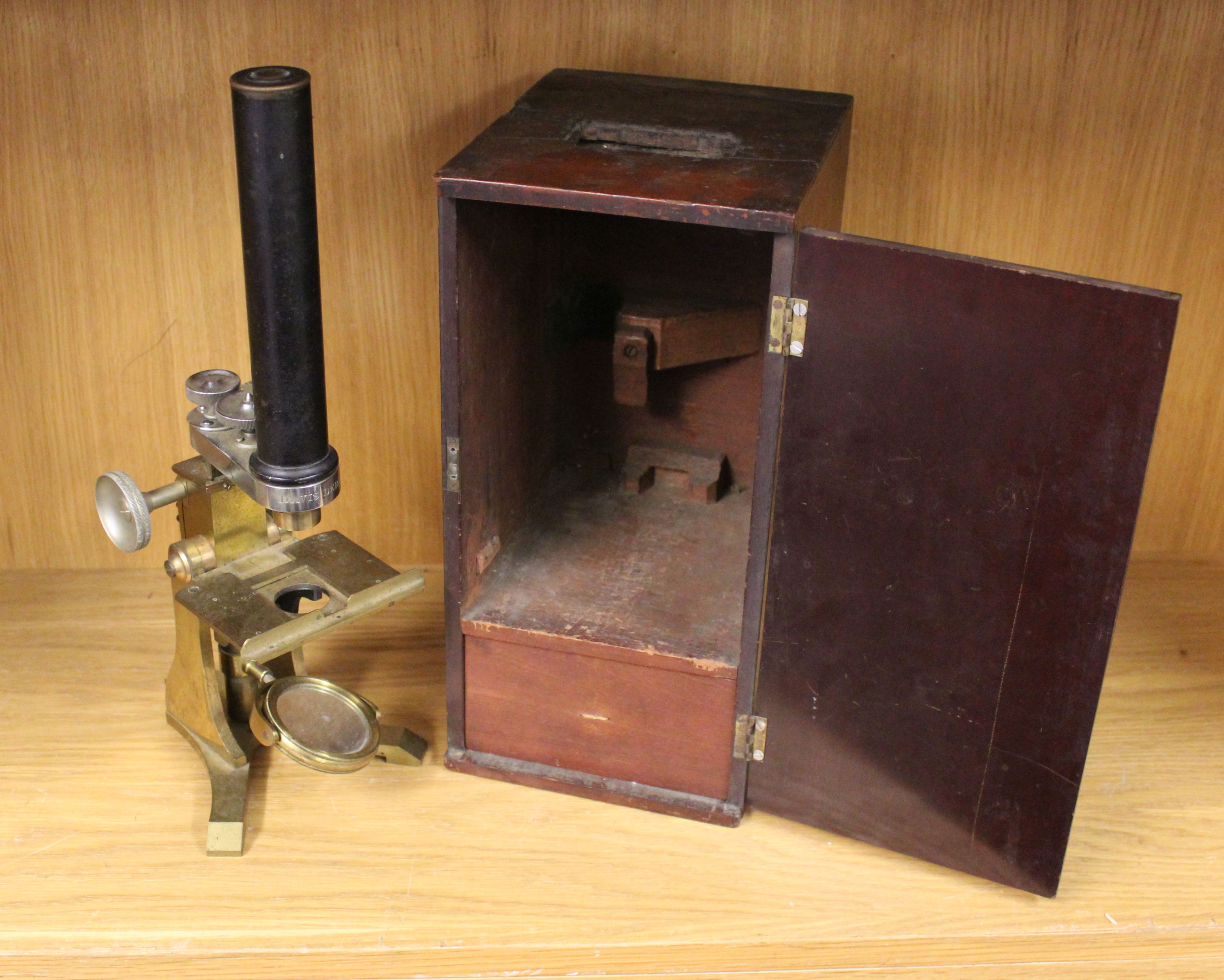 An Edwardian brass microscope, with mahogany carrying case and two additional lenses.