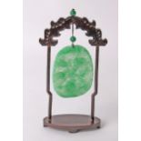 Two carved jade panels on Oriental hardwood hanging stands.