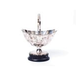 A Georgian sterling silver scalloped shaped footed bowl, with swing handle on ebony base, by William