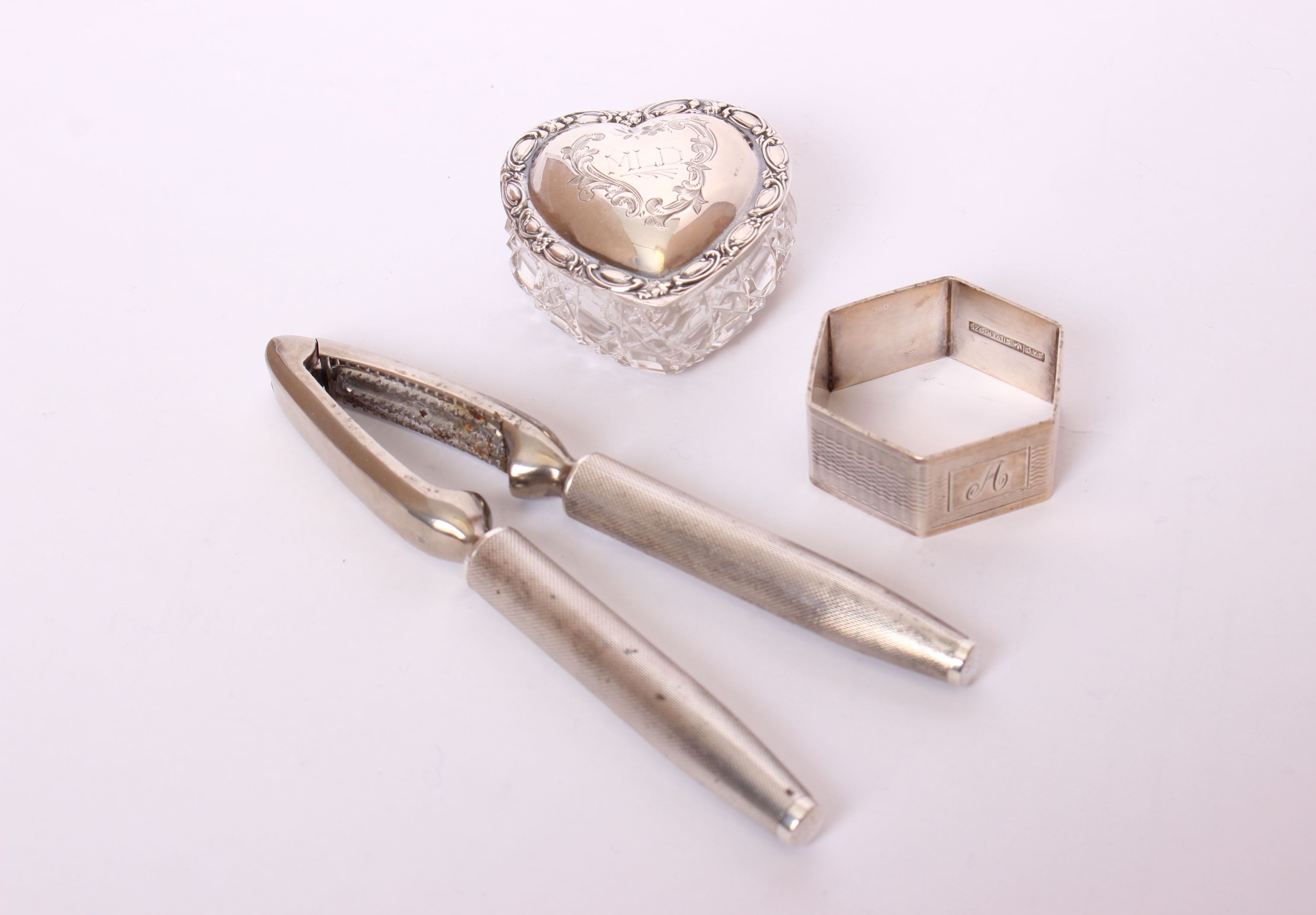 A pair of sterling silver handled nut crackers by Mappin & Webb; together with a heart shaped silver