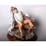 A Capodimonte style figure of a tramp on a bench with a dog, marked 'Italy 325/A', on turned