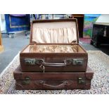 Two matching vintage leather suitcases.