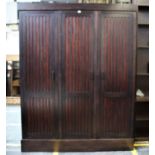 A Continental stained oak wardrobe with three full length slatted doors, 168cm wide, 220cm high.