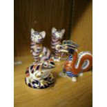 A pair of Royal Crown Derby porcelain models of cats, together with a similar model of a frog and