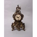 A brass Rococo style mantle clock, with white painted dial and Arabic markers with later quartz