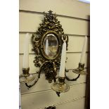 A pair of Victorian brass three-branch girandoles, with an oval mirror, 37cm high; together with a