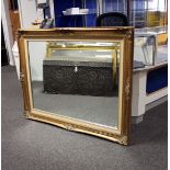 A large gilt framed wall mirror with bevelled glass plate. 125cm x 100cm.