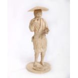 A Japanese carved ivory figure of a fisherman, standing smoking a pipe holding a lobster in his left