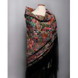 An early 20th Century black silk fringed Chinese shawl, with a densely embroidered design of a
