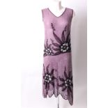 A 1920s pale mauve and white sleeveless floral patterned bead evening dress with a scalloped hem and