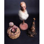 A 1920s composition head pin cushion; a 1930s composition head wearing a pale mink wrap on a pink