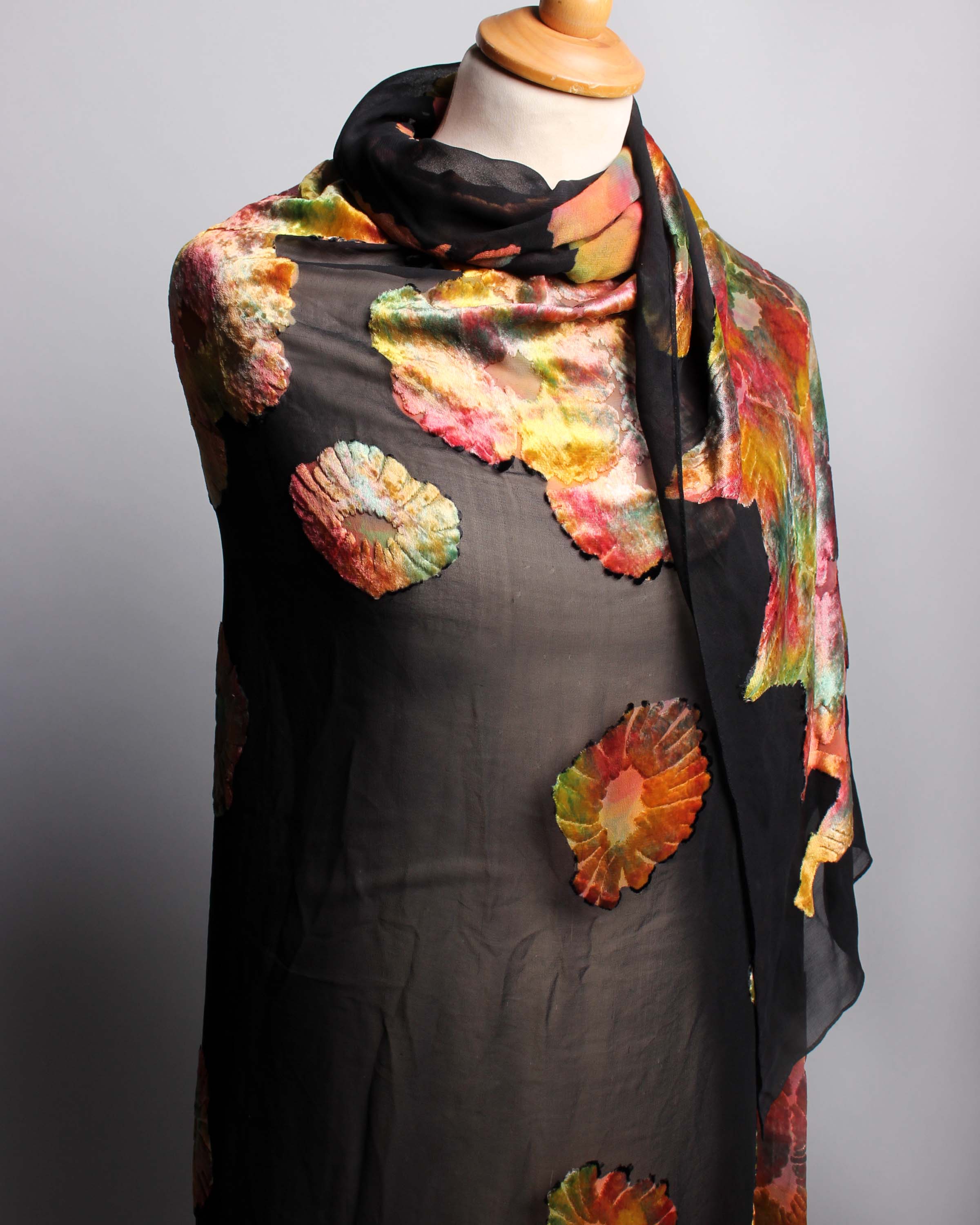 An early 20th Century black silk devoré shawl, decorated with stylised brightly coloured flowers.